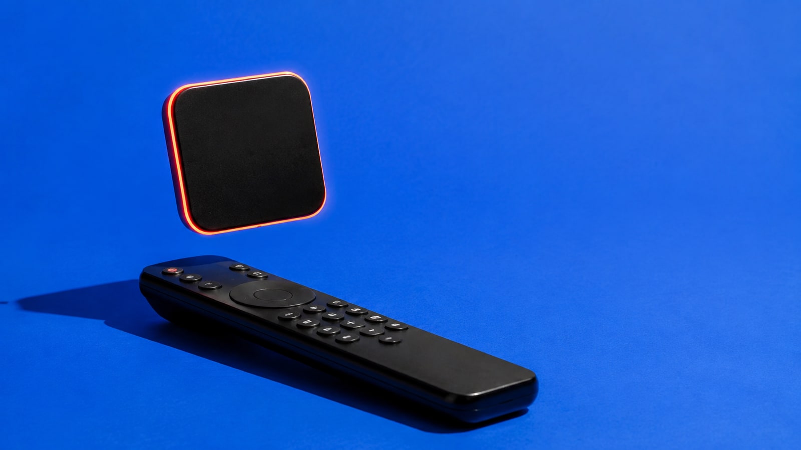 Blank glowing app tile floating over an unbranded television remote on cobalt blue