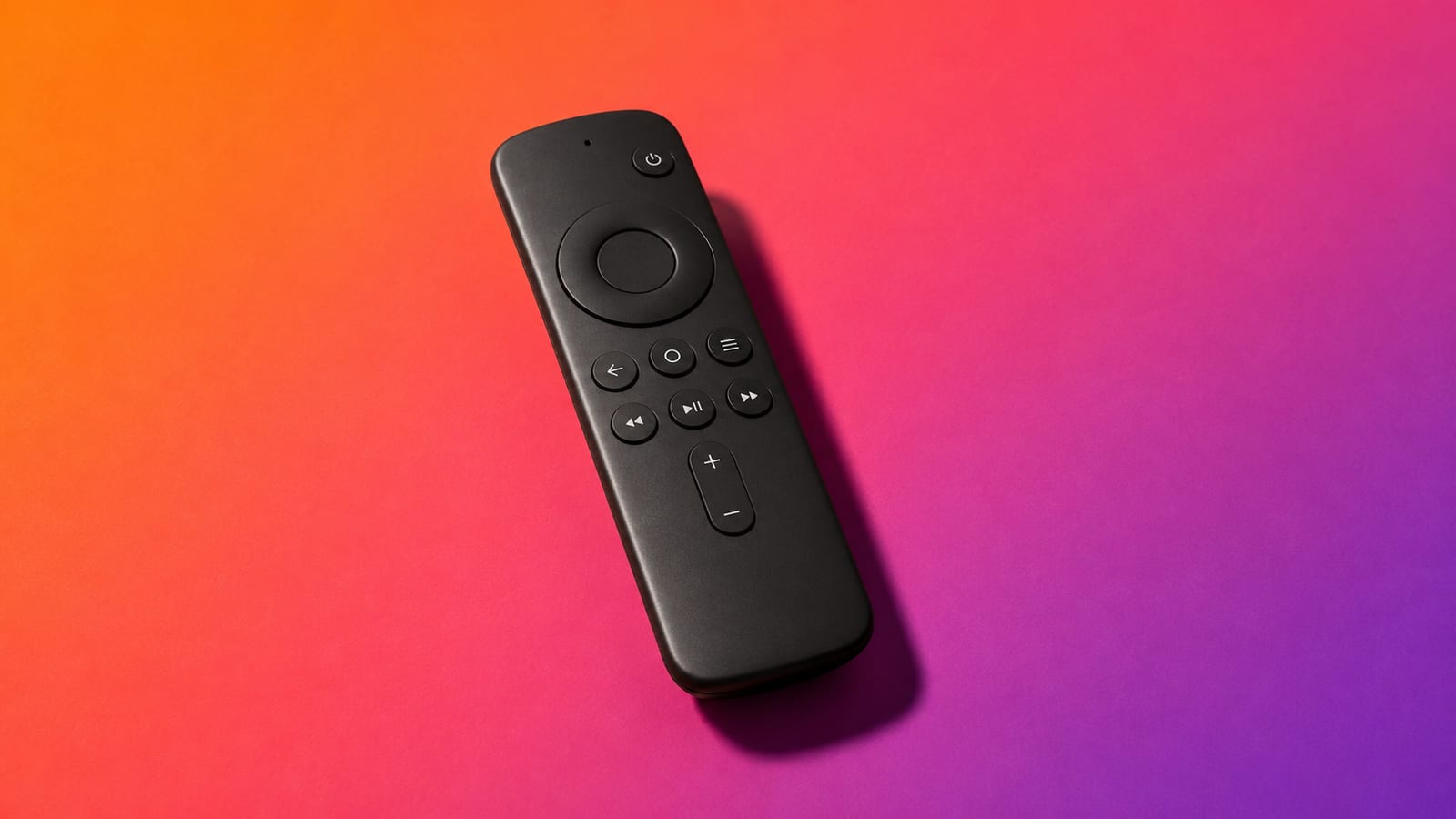 A matte-black streaming remote on an orange-to-violet studio background