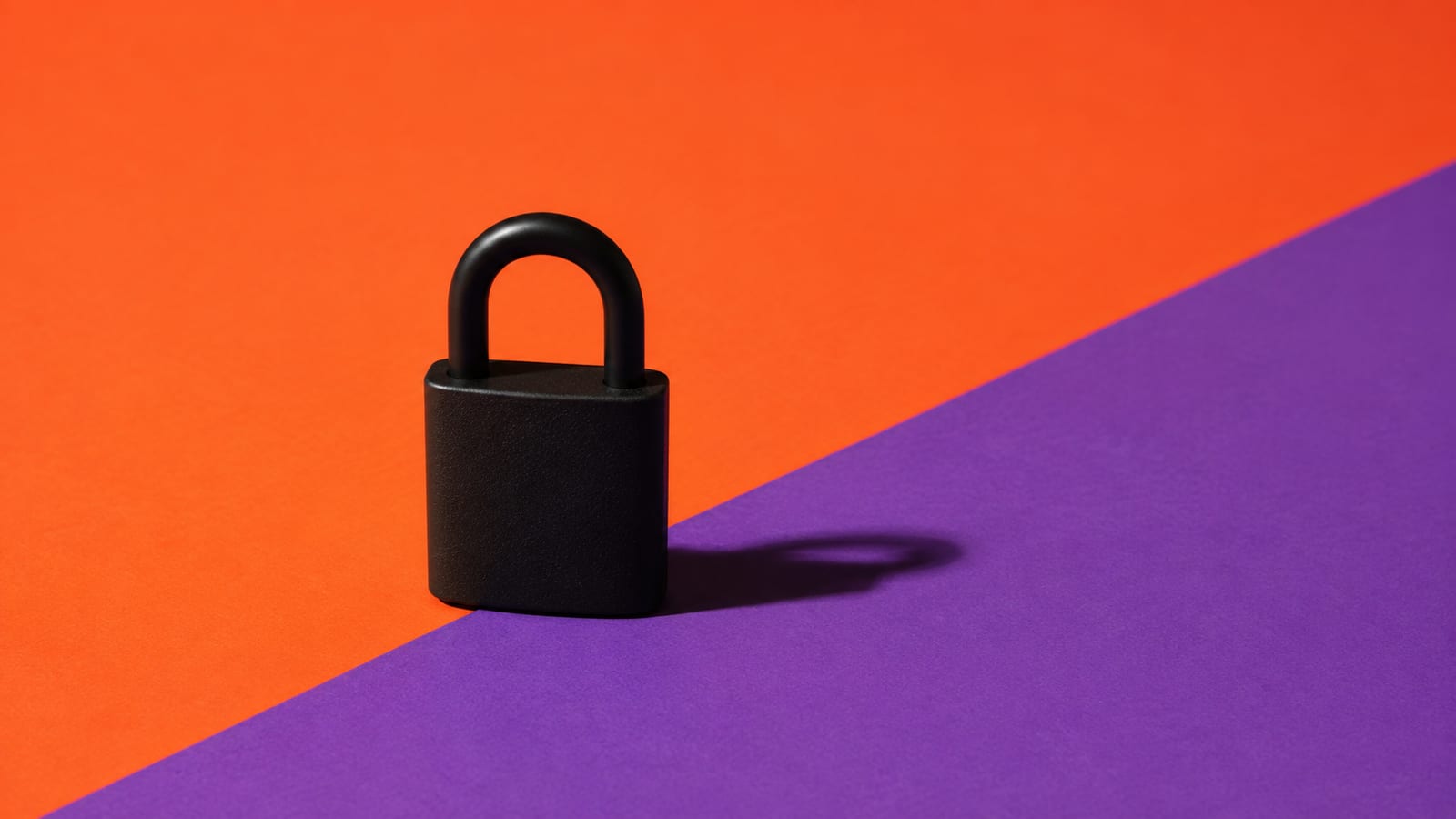 A matte-black padlock on a split orange and violet background
